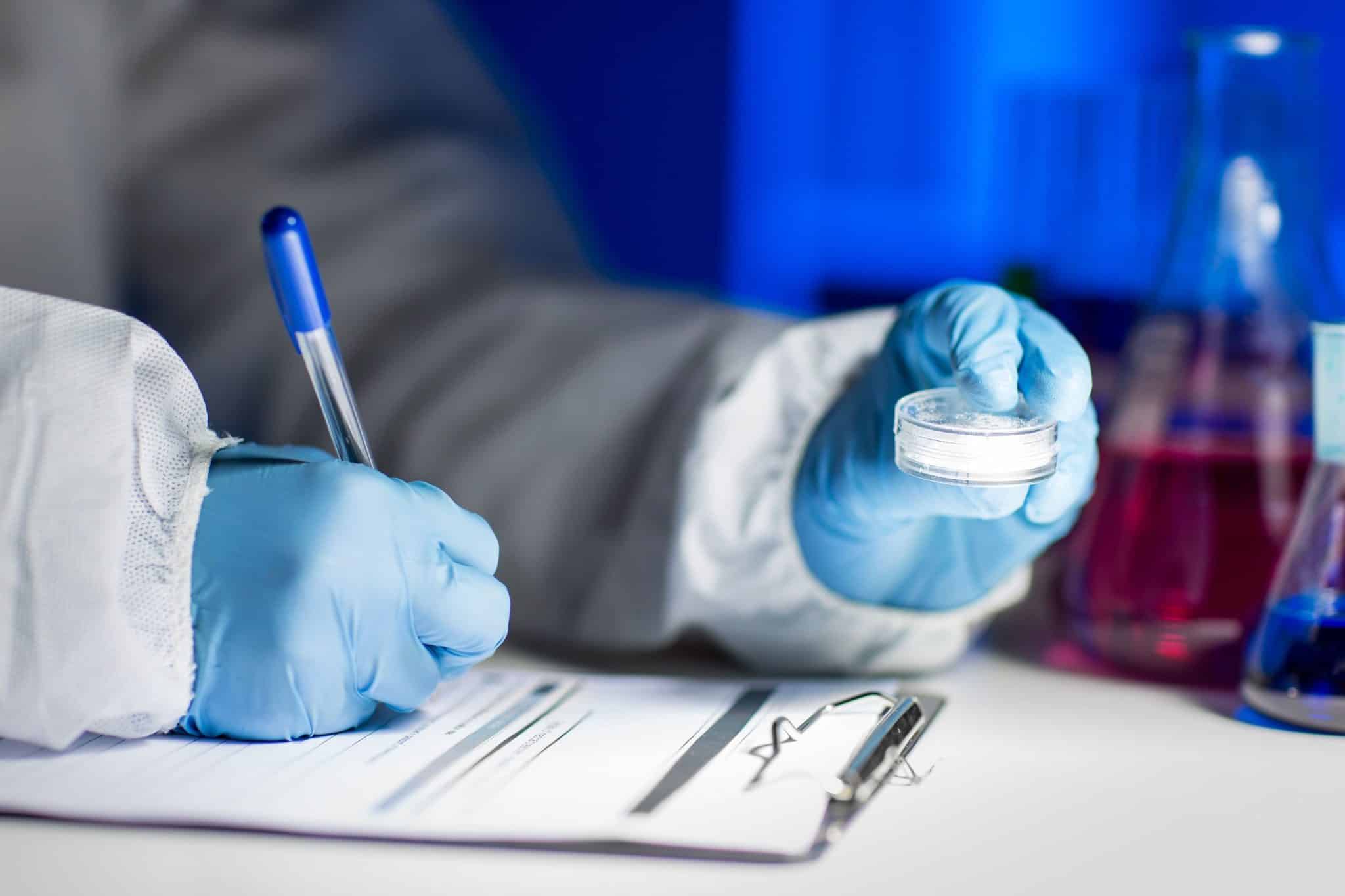 Close-up of lab worker writing down medication information