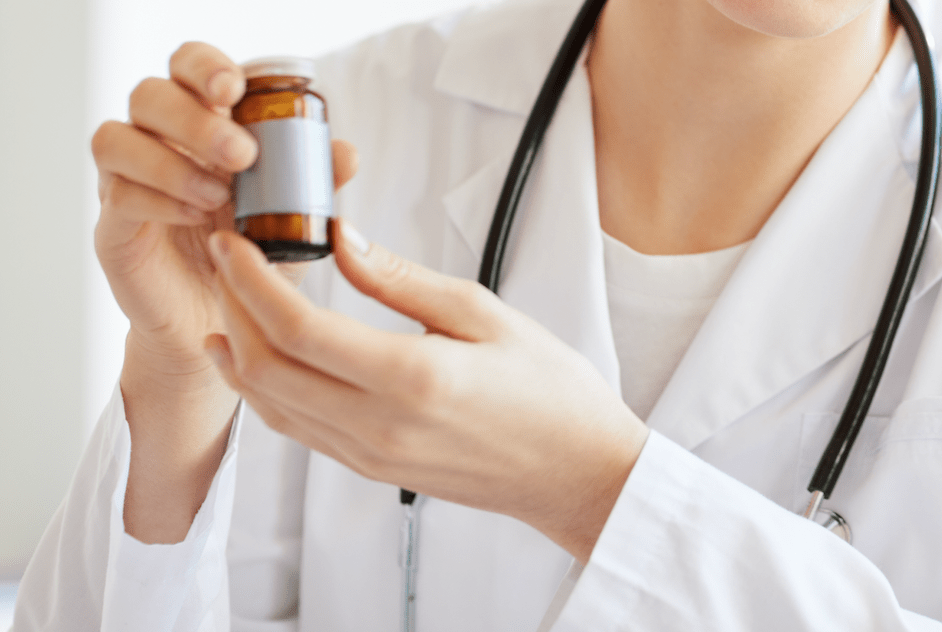 Doctor Holding Up Vial of Vitamins