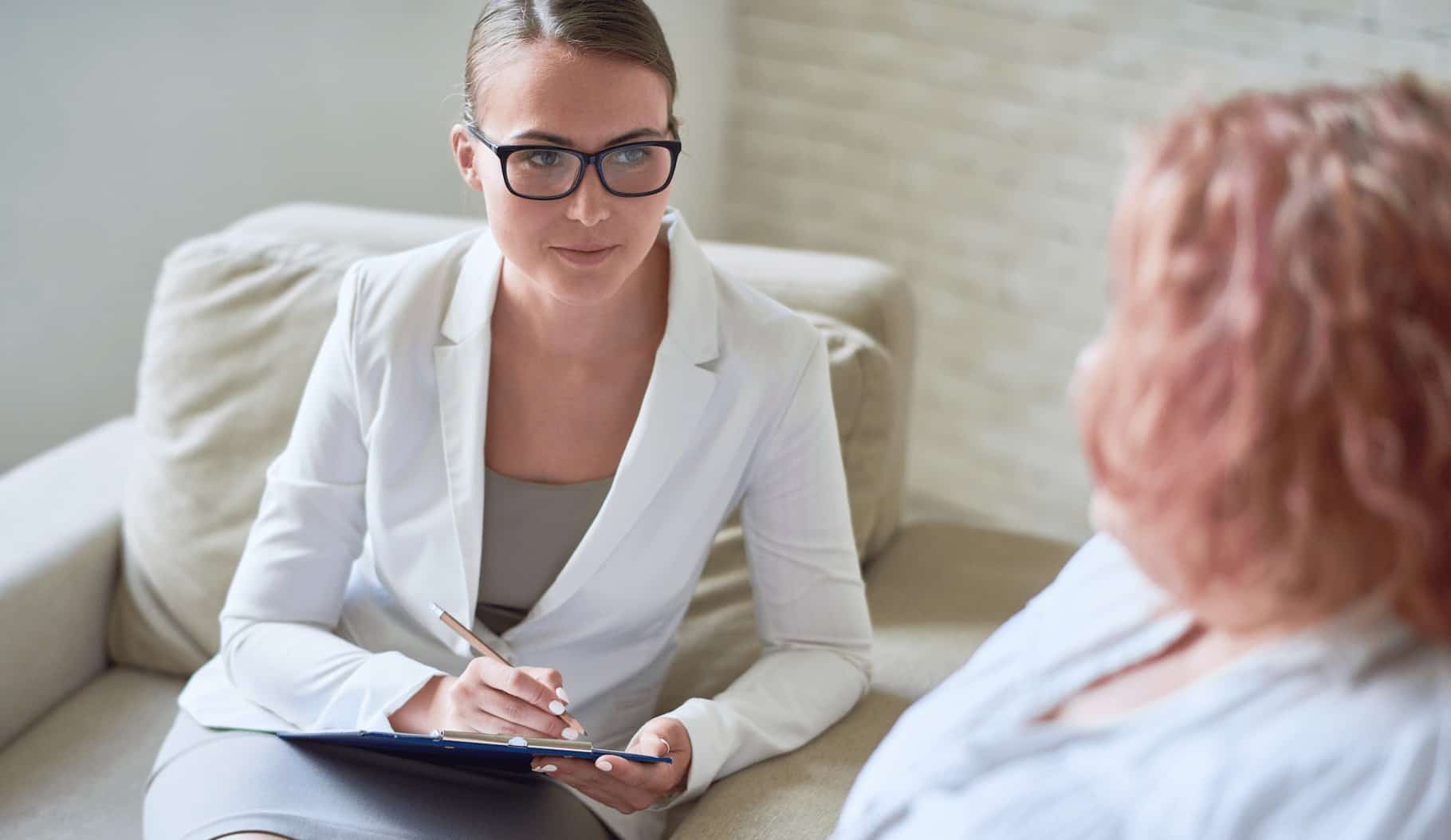 Physician sitting with obese patient and filling out paperwork